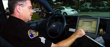 Policing Sgt. Thomas Navin of the San Jose Police Department enters data into a patrol car's computer system. The system has baffled some officers.